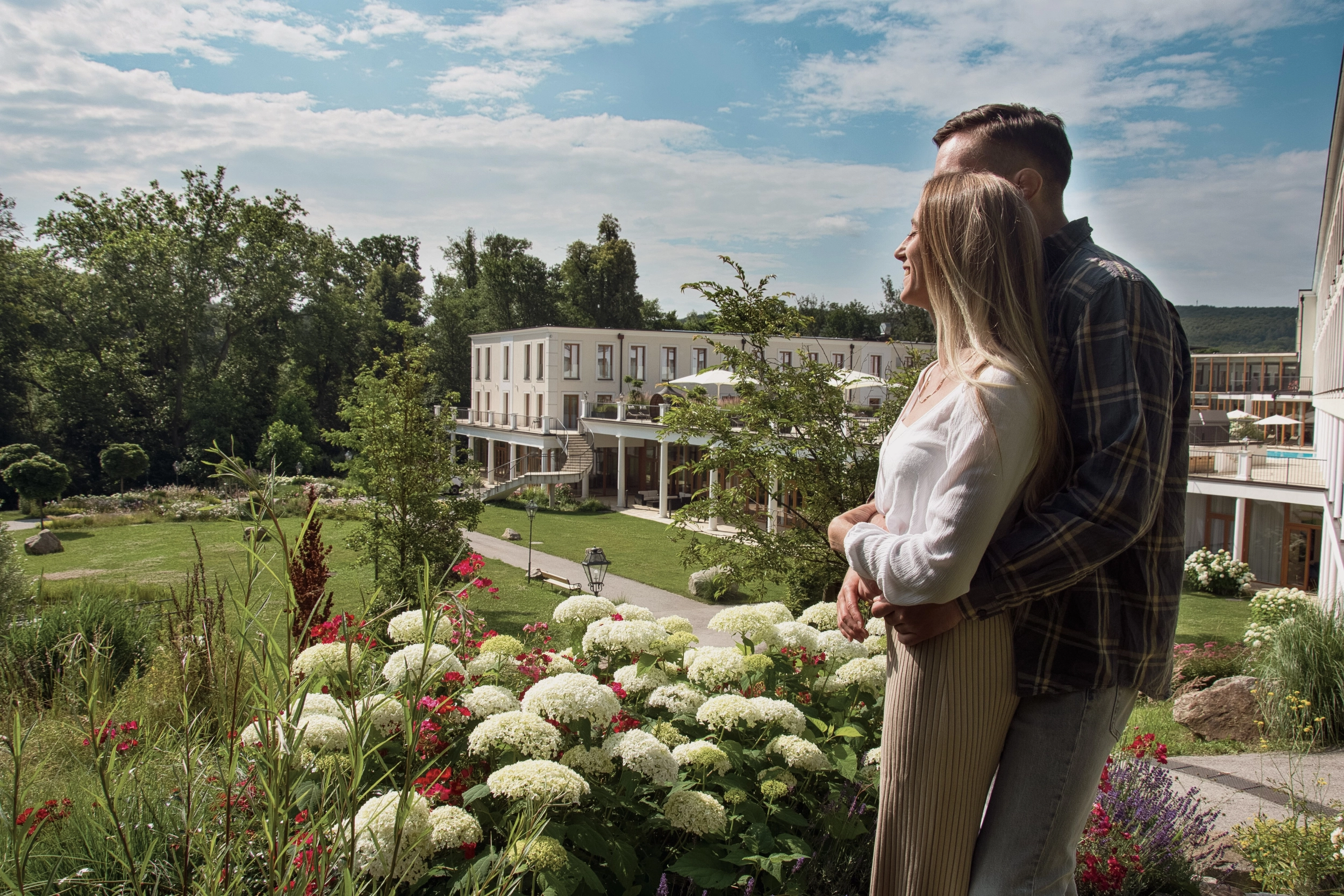 Paar blickt auf den Park des 4*s Hotel Schlosspark Mauerbach